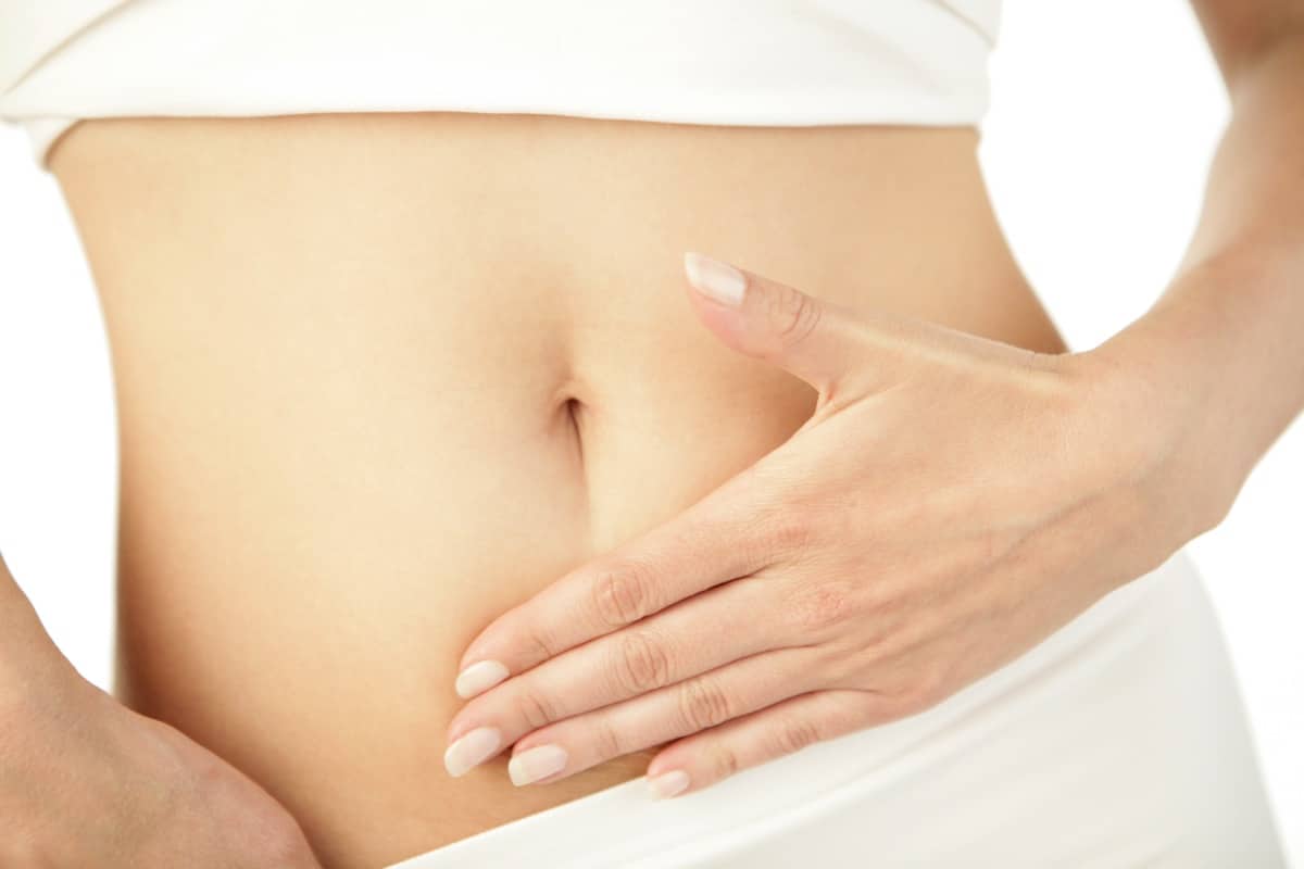 Closeup of young woman with hand on her stomach