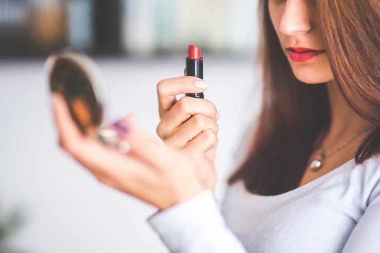 ragazza mette il rossetto