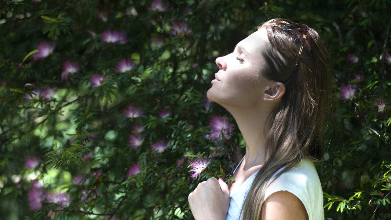 Donna in mezzo alla natura che respira