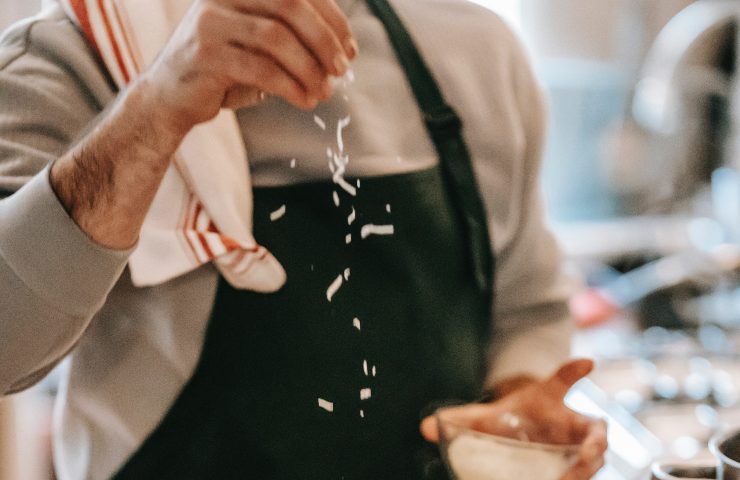 italiano mette il formaggio sulla pasta