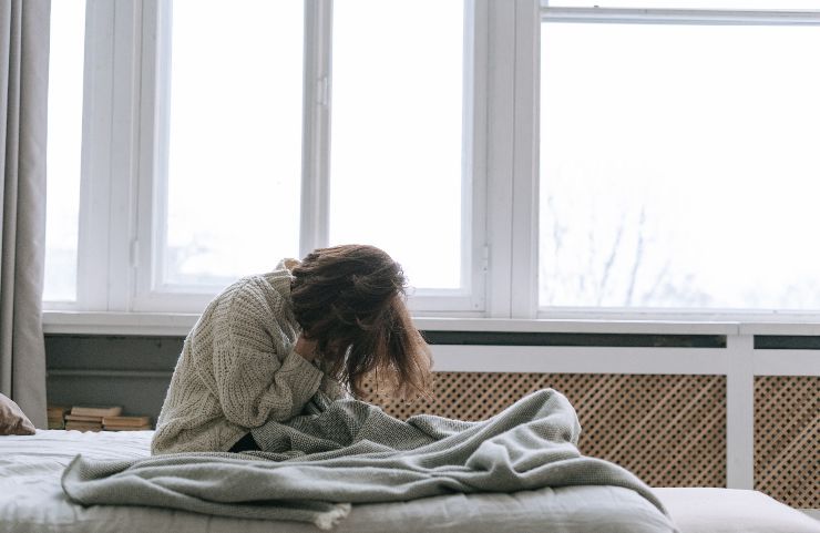 Ragazza si tiene la testa con le mani in stato di ansia