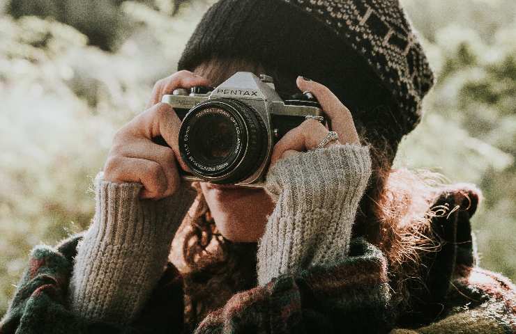 Donna con macchina fotografica e sguardo sull'obbiettivo