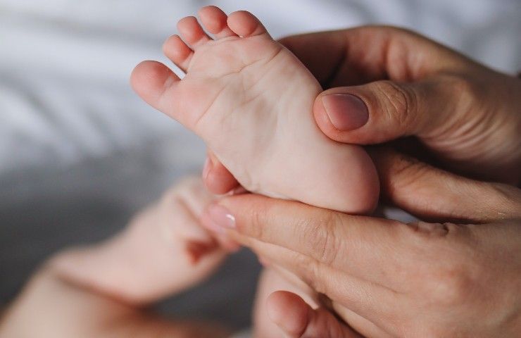 Massaggio ai piedi di un neonato