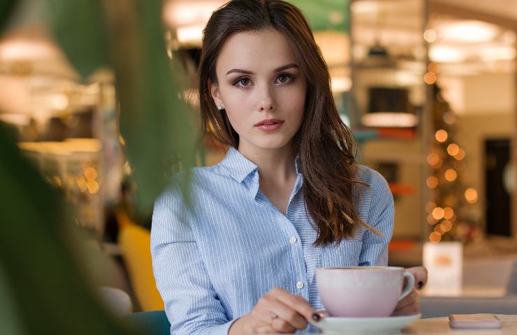 Donna prende un caffè in camicia