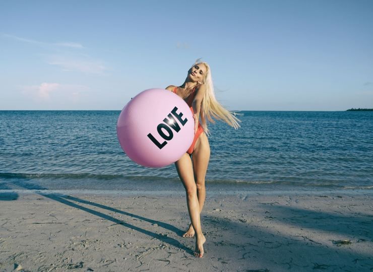 ragazza con pallone gonfiabile in spiaggia