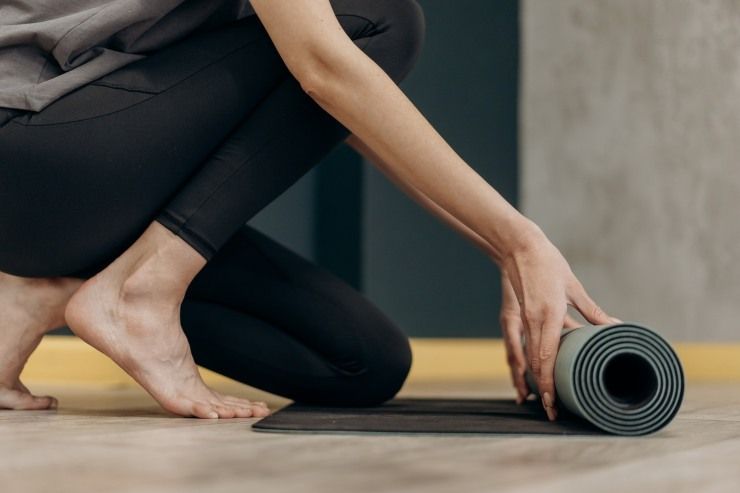 donna con tappetino per lo yoga