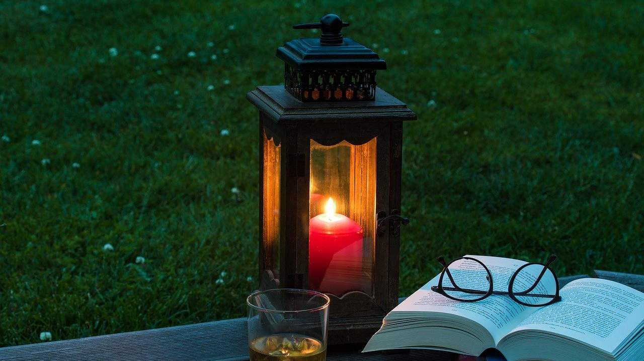 Lanterna in legno per giardino, libro e occhiali