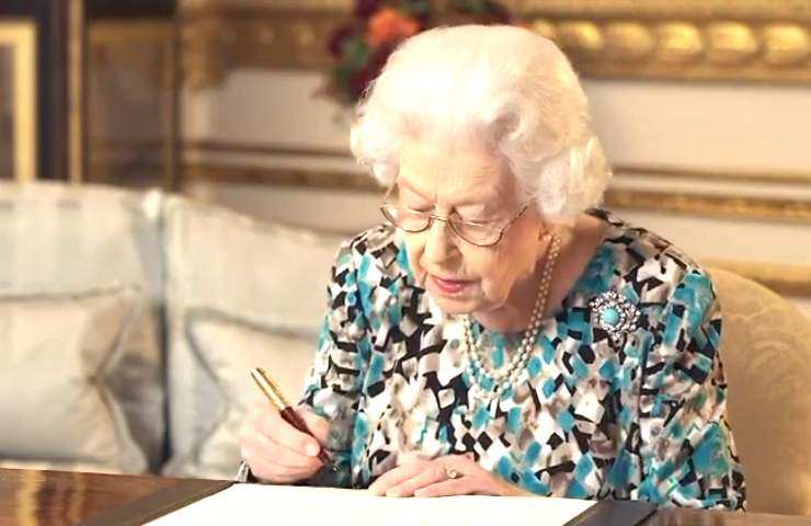 La regina Elisabetta mentre firma un documento