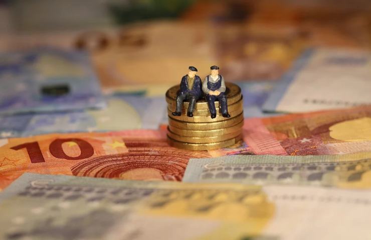 Monete e banconote in euro con due statuine