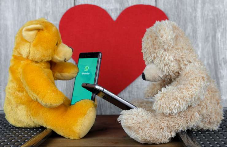 Pupazzi e smartphone con cuore sullo sfondo