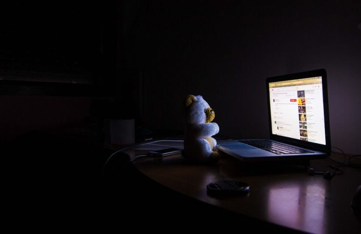 Un pupazzo davanti ad un pc acceso di notte