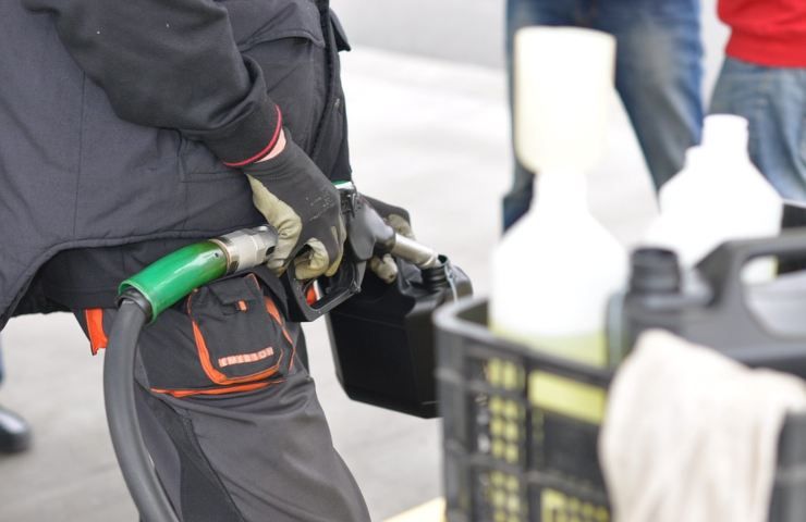 Un uomo riempie un contenitore con del carburante