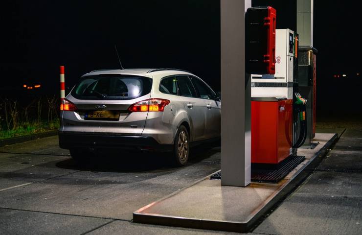 Un'auto fa rifornimento di carburante nella notte