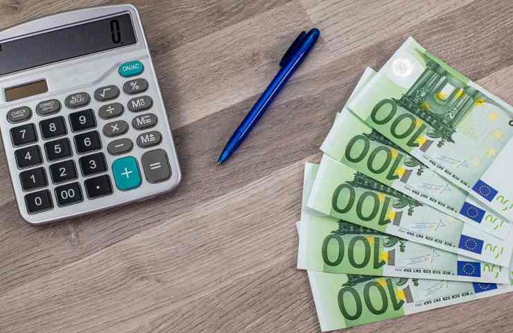 Banconote da cento euro con penna e calcolatrice