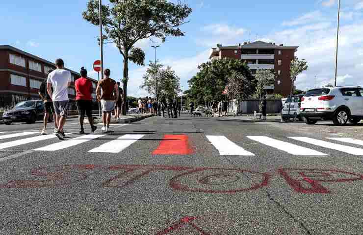 Dei pedoni camminano al centro della strada