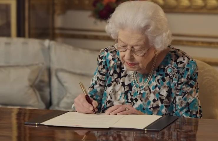 La regina mentre firma un documento