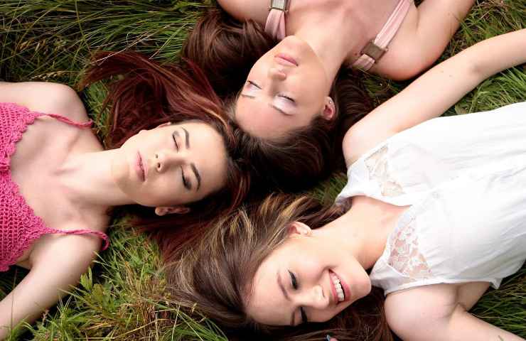 Tre donne distese sull'erba