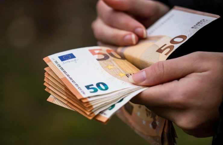 Un uomo conta delle banconote da 50 euro
