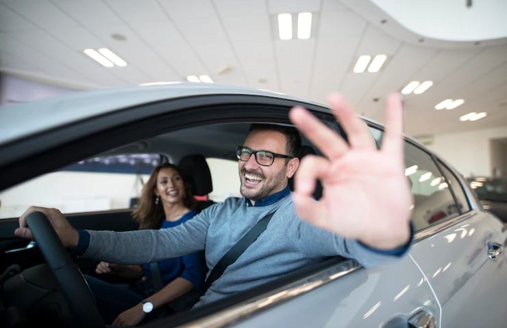 Un uomo ed una donna sorridenti in auto