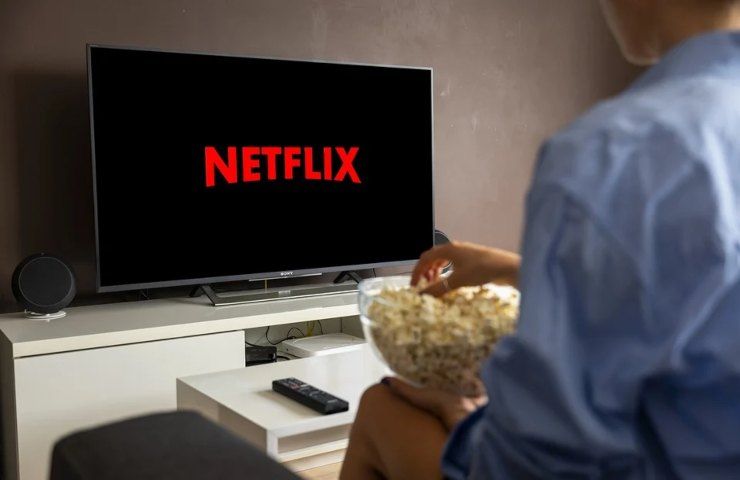 Un uomo gusta dei popcorn mentre avvia Netflix