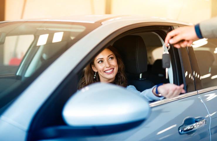 Una donna in auto riceve le chiavi del veicolo