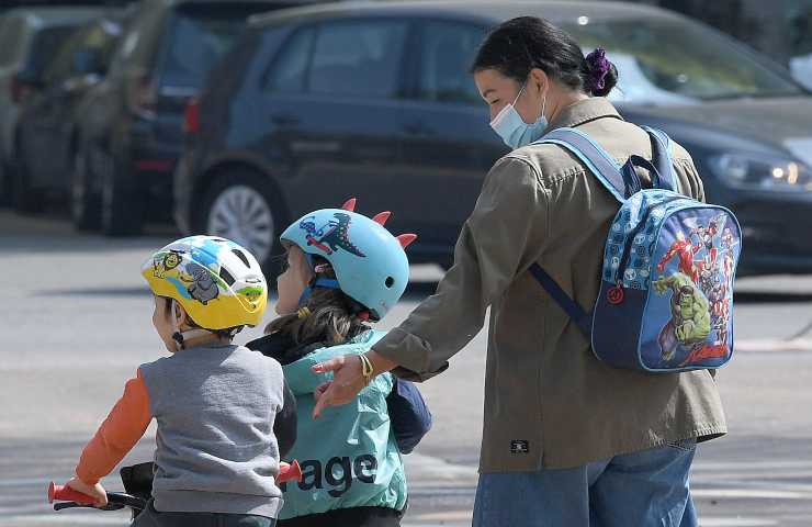 Una donna passeggia con i suoi due figli piccoli