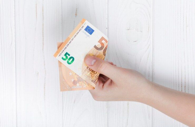 Una persona porge una banconota da 50 euro