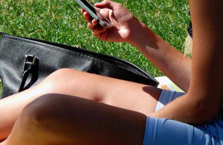 Una ragazza sta usando il suo telefonino