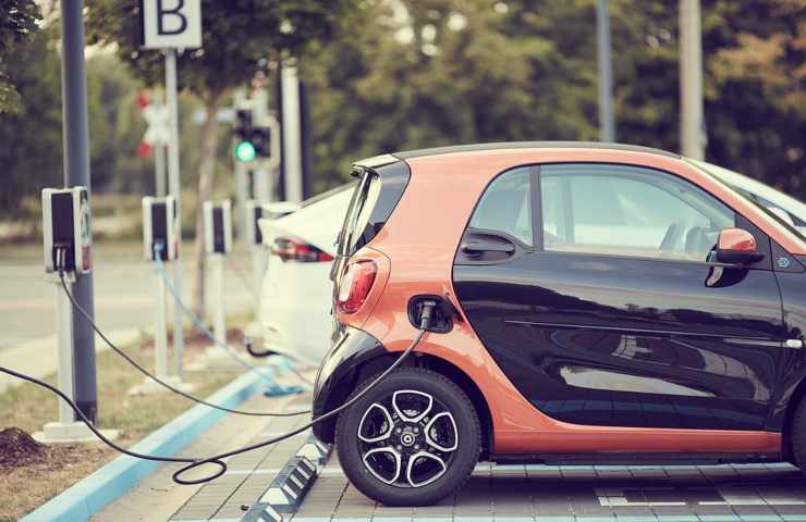 Un'auto elettrica in ricarica ad una postazione pubblica