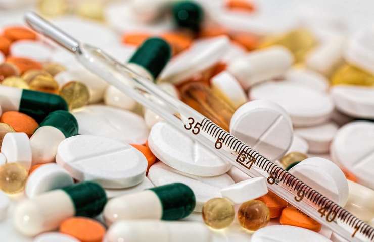 Diverse capsule e pillole medicinali ed un termometro