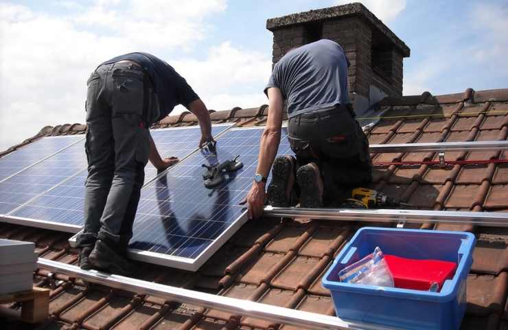 Due operai installano dei pannelli fotovoltaici
