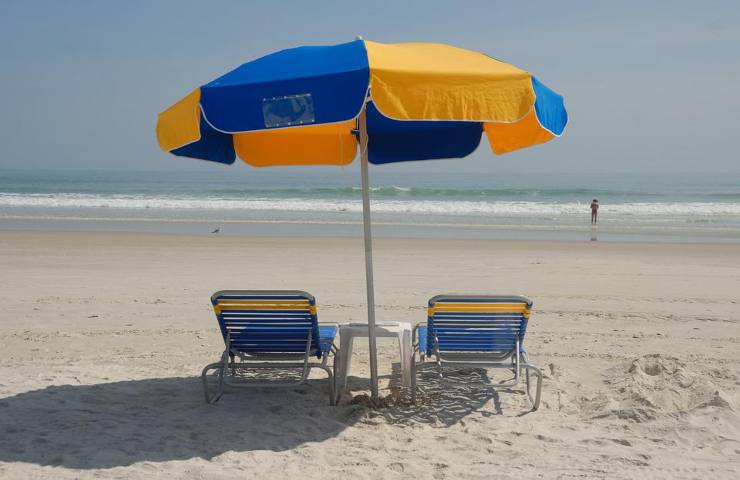 Un ombrellone e due lettini in spiaggia