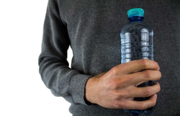 Un uomo tiene una bottiglietta di acqua