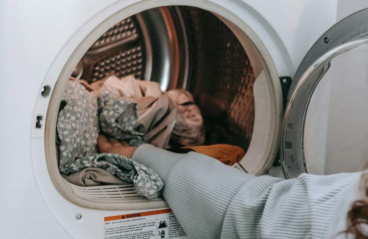 Una donna riempie la lavatrice