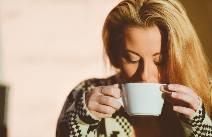 Una ragazza beve da una tazza