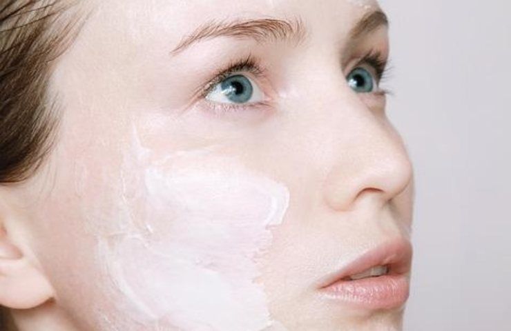 Una ragazza con della crema di bellezza sul volto