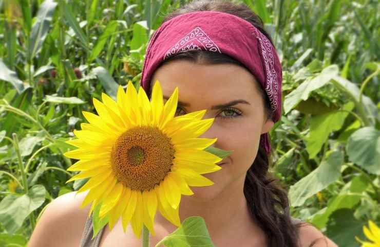 Una ragazza con un girasole in un campo