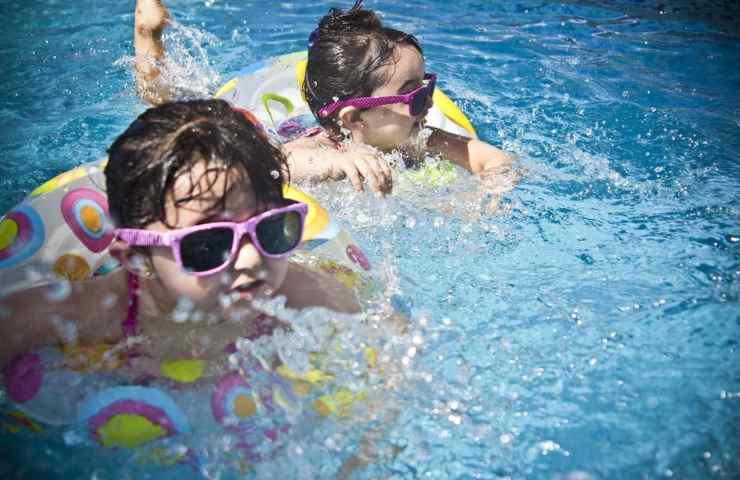 Due bambine nuotano in piscina