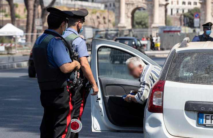 I carabinieri controllano un uomo ad un posto di blocco