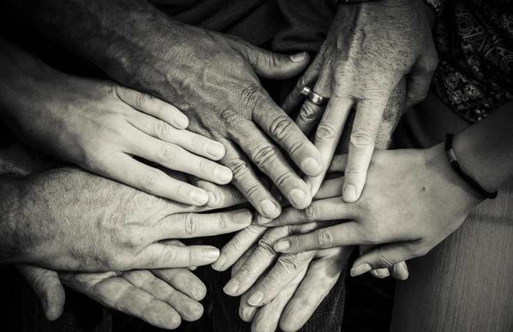 Le mani unite di diverse persone anche anziane