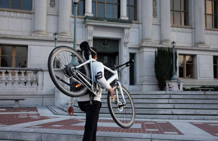 Un uomo regge la propria e-bike in spalla
