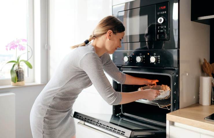 Una donna mentre usa il forno a casa
