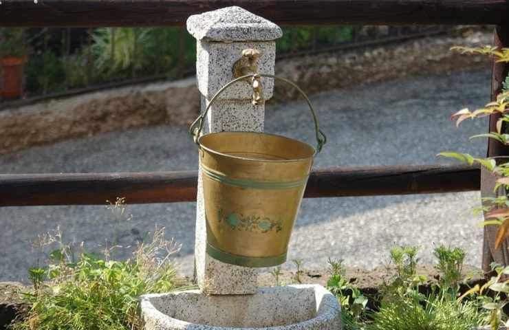 Una fontana chiusa con un secchio per raccogliere le gocce