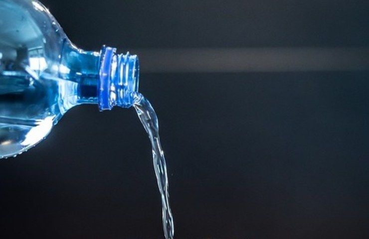 Dell'acqua minerale versata da una bottiglia