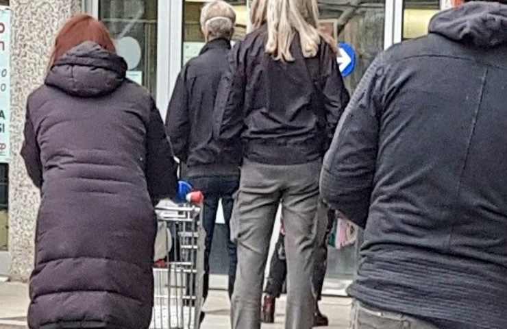 Delle persone in fila ad un supermercato