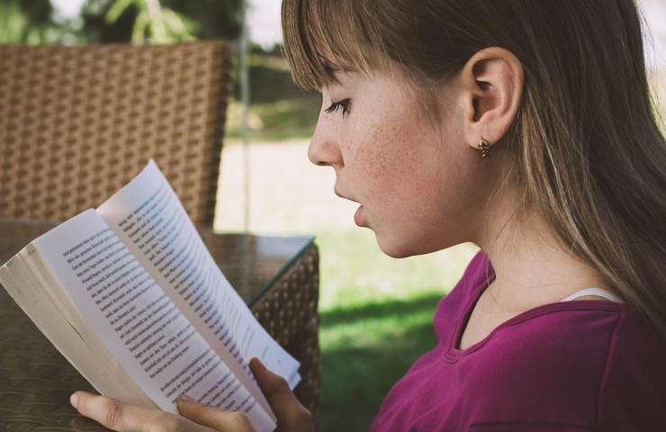 Una ragazza mentre legge un libro