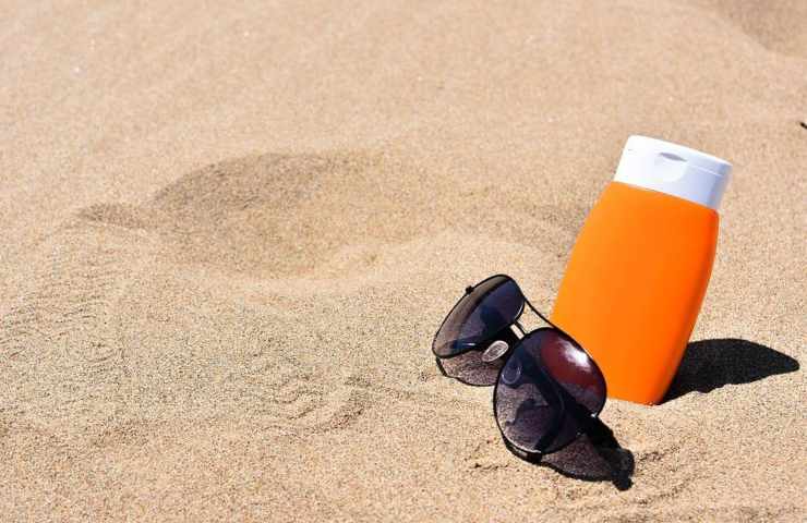 Della crema anti raggi e degli occhiali sulla sabbia