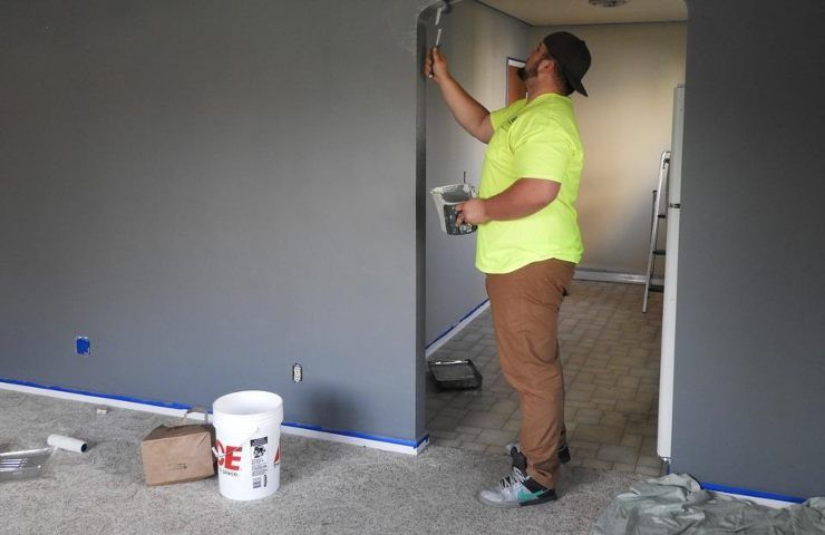 Un uomo dipinge delle pareti in casa