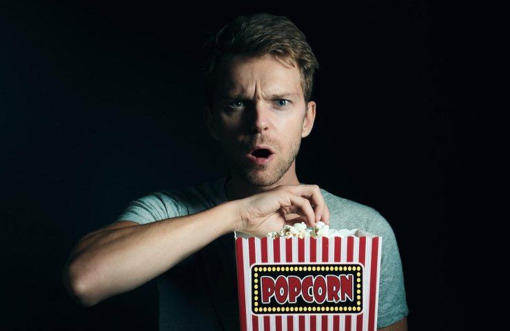 Un uomo mentre mangia dei popcorn