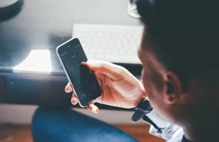 Un uomo mentre regge uno smartphone